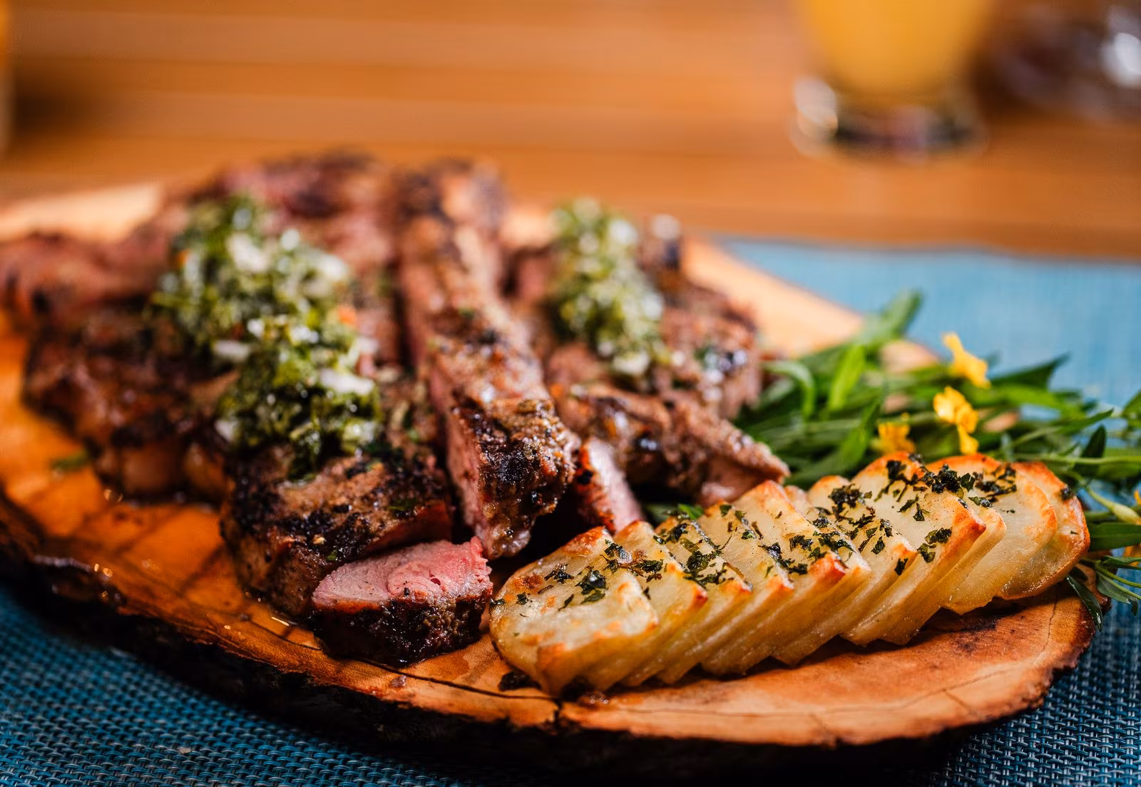 Grilled meats and potatoes served on a wooden board